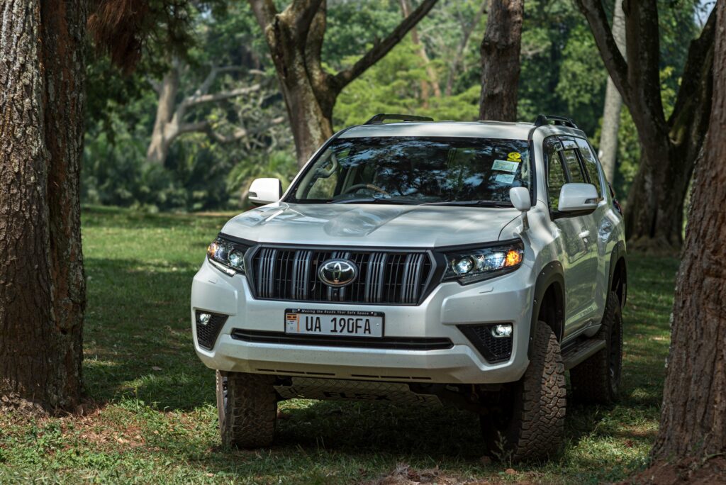 White Toyota Land Cruiser Prado parked under trees