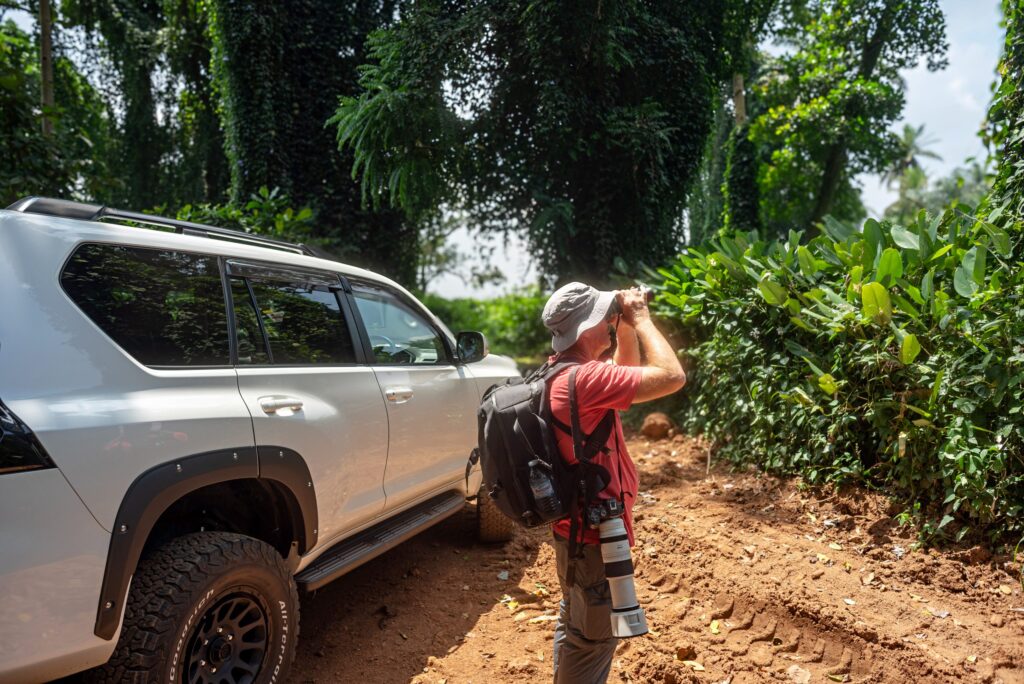 Birdwatching beside the Land Cruiser on a red dirt road